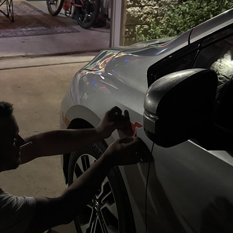 Applying a fresh Dillo sticker at night in the driveway
