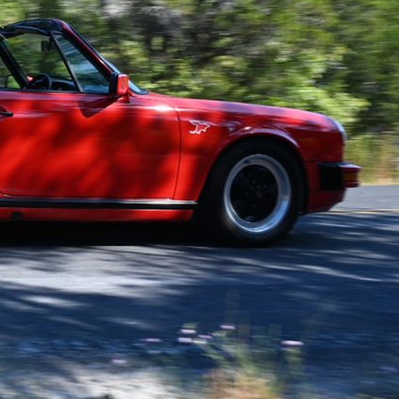 Dillo sticker on a red classic Porsche 911 Cabriolet on a Hill Country road